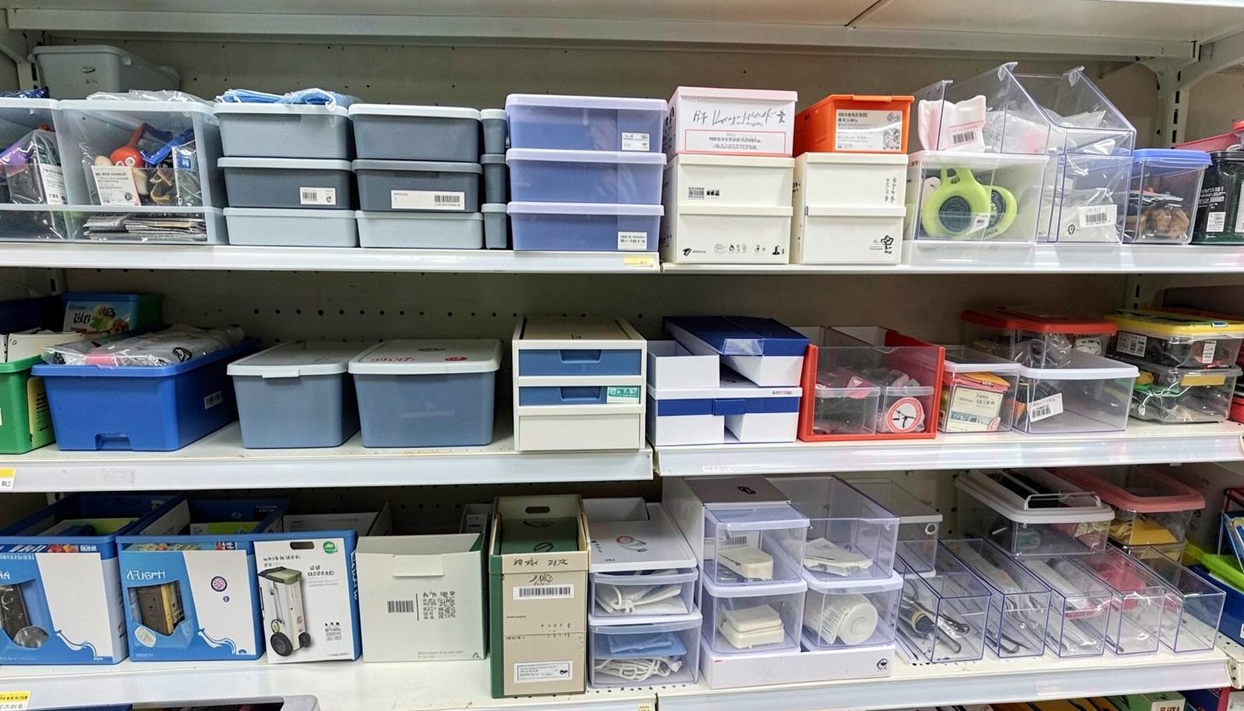 Card supplies including toploaders, storage boxes, and lucite holders neatly organized on store shelves, clean and orderly.